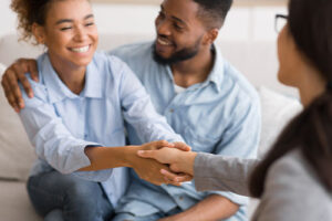 a young couple greeting the therapist as the prepare to engage in a family therapy program