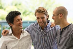three men congratulating each other at completing a mens rehab program