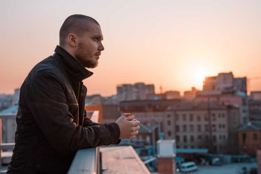 young man standing on rooftop at sunset contemplating alcohol withdrawal timeline