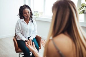 female therapist explaining acceptance and commitment therapy to a female client
