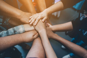 close up image of people in a circle putting their hands together in a team celebration of finding opioid addiction treatment in Asheville, NC.