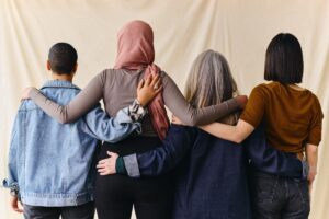 photo of a group of women taken from behind where all are standing together with arms around each other's shoulders as a result of finding a women's rehab program in North Carolina