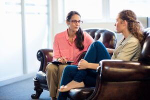 young woman talking with addiction treatment specialist about the benefits of dialectical behavior therapy for addiction treatment.