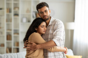 young man hugging a young woman asking how to help a loved one with alcohol addiction