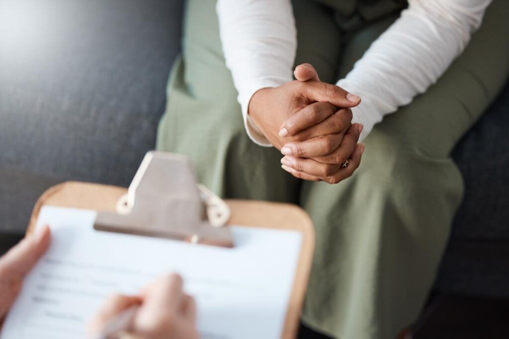 close up of a therapist's clipboard as they review the benefits of a trauma therapy to a patient sitting across from them.