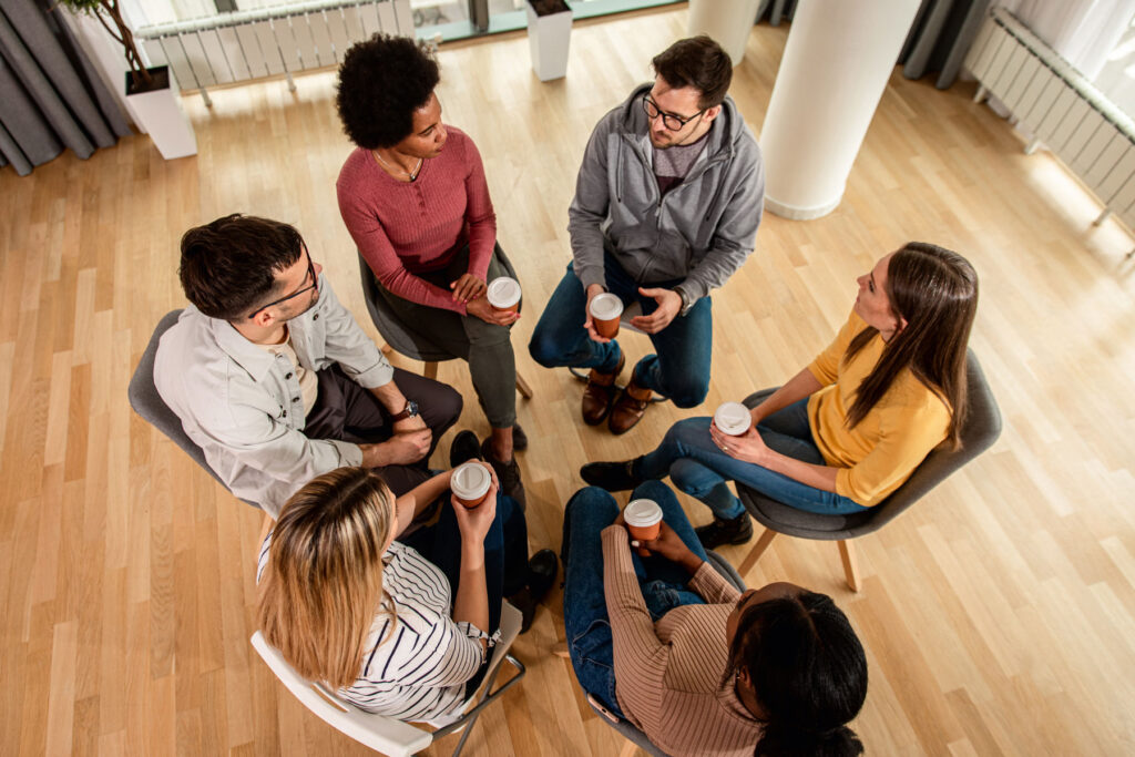 group of men and women sitting in a circle and sharing from experience what a typical day in alcohol rehab is like.