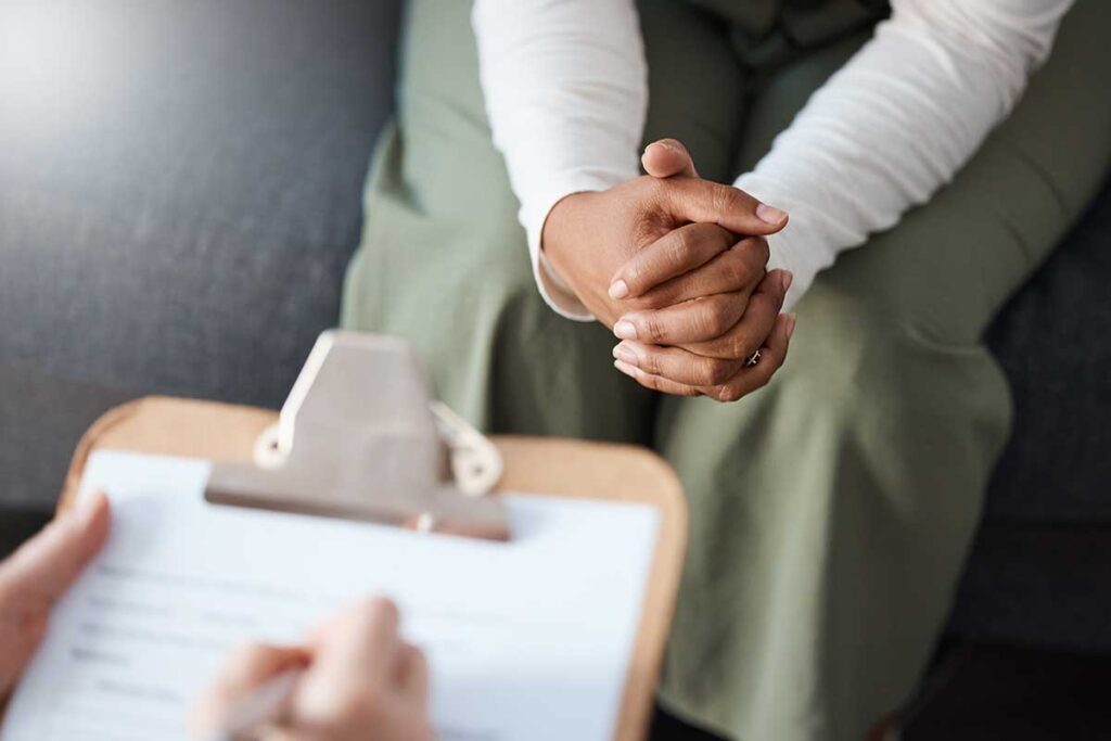 close up of a clipboard held by an addiction treatment specialist as they talk with a client about prescription drug misuse and how it happens and when to seek help.
