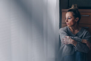 A woman wondering, "Do women get addicted to alcohol faster than men?"