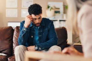 Clipboard, conversation and therapist with man in office with checklist for mental health evaluation. Coach, patient information and psychologist with person for support of stress, ptsd or anxiety